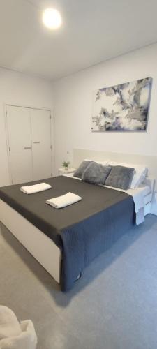 a bedroom with a large bed with towels on it at Porta 80 House in Braga