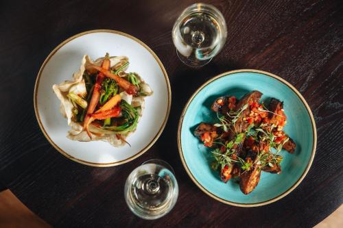 three plates of food on a wooden table at Hotel Indigo London Clerkenwell by IHG in London
