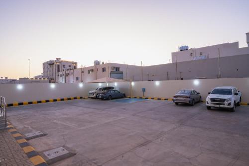 a parking lot with cars parked in front of a building at Grand Line Hotel in Tabuk