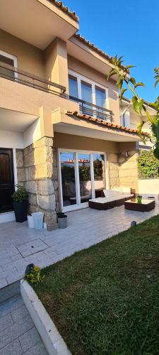a house with a patio in front of it at Mãe Maria House Guest House in Vila Chã
