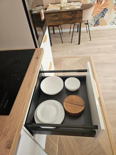 three white plates on a black tray in a kitchen at Maison Ethno Chic proche de Paris et d'Orly in Morangis
