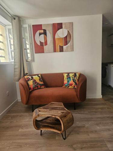 a living room with a brown couch and a table at Maison Ethno Chic proche de Paris et d'Orly in Morangis