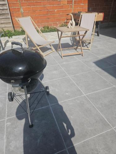 a grill and two chairs and a table on a patio at Maison Ethno Chic proche de Paris et d'Orly in Morangis