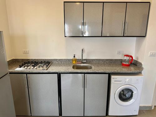 a kitchen with a sink and a washing machine at Nomads Hostel in Dahab