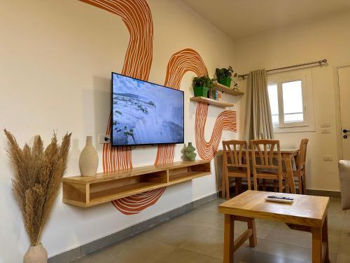 a living room with a flat screen tv on a wall at Nomads Hostel in Dahab
