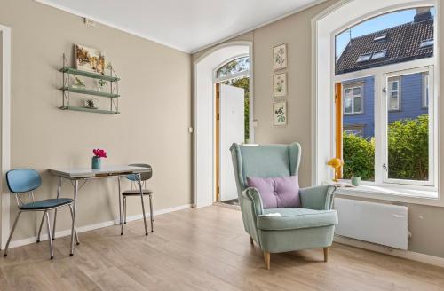 a living room with a chair and a table at Eden Oasis, Bakklandet with Free parking! in Trondheim