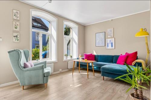 a living room with a blue couch and two chairs at Eden Oasis, Bakklandet with Free parking! in Trondheim