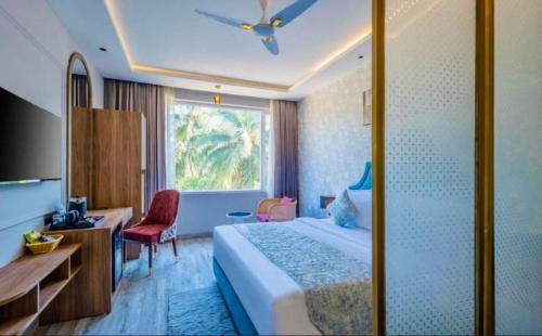a hotel room with a bed and a desk and a window at The Boho Calangute Goa in Calangute