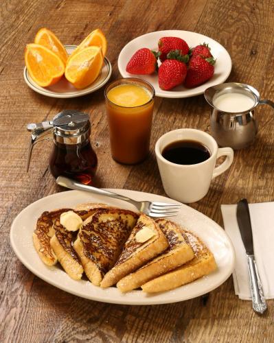 a table with two plates of french toast and fruit at The Commune Banaras in Varanasi