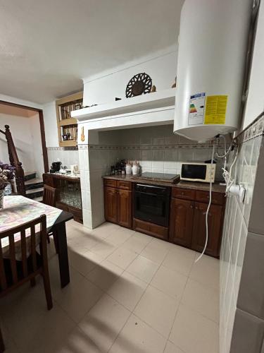 a kitchen with wooden cabinets and a stove top oven at Ninho da Cegonha Assumar in Assumar