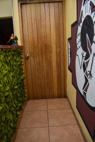 a room with a wooden door and a green hedge at Passion Hostel - Barranco in Lima