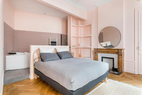 a bedroom with a bed with a fireplace and a mirror at Lovely - balnéo confort absolu -Parking in Saint Etienne