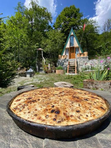 a large pizza sitting in front of a house at Kafe Pojana in Tropojë