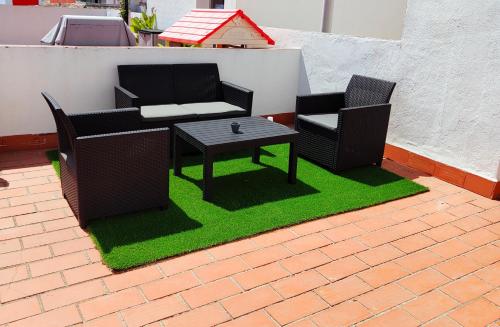 a patio with two chairs and a table on grass at Los Deseos De Vera in La Cala de Mijas