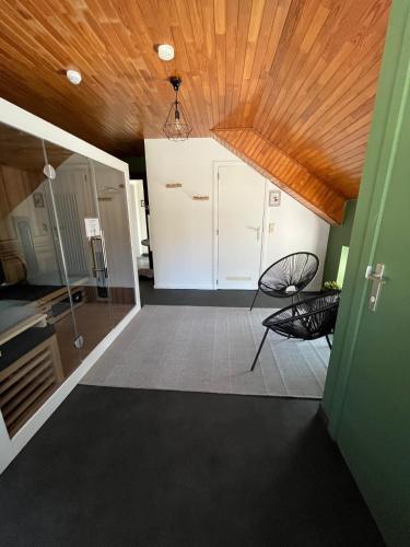 a room with two chairs and a ceiling at La Belle Vie aux Quartes in Rendeux