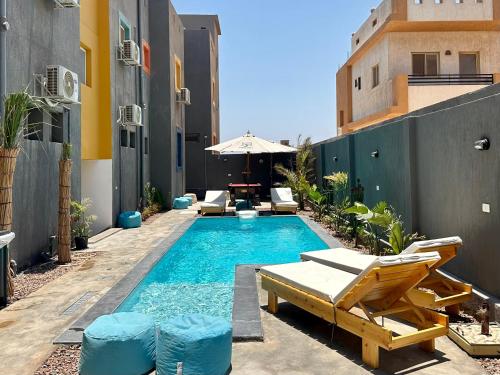 a small swimming pool with chairs and an umbrella at Nomads Hostel in Dahab