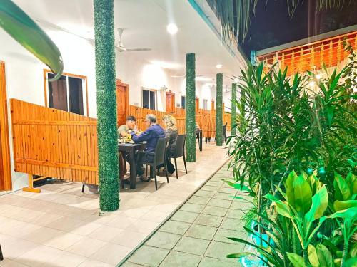 two people sitting at a table in a restaurant at Sunny Beach Thoddoo in Thoddoo