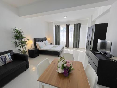 a living room with a table and a couch at CARIBBEAN STUDIOS DELUXE with ROOFTOP POOL and SPA - LOS CORALES BEACH in Punta Cana