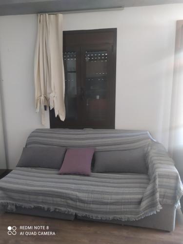 a bed with a pink pillow on top of it at Evelina's House in Tolo