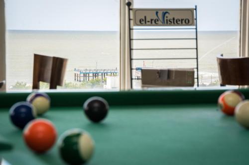 a pool table with balls in front of a window at Hotel Paucam in Santa Teresita