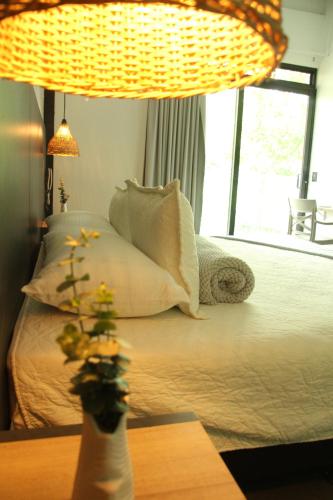 a bedroom with a bed with pillows and a window at Hotel Capri Doradal in Doradal