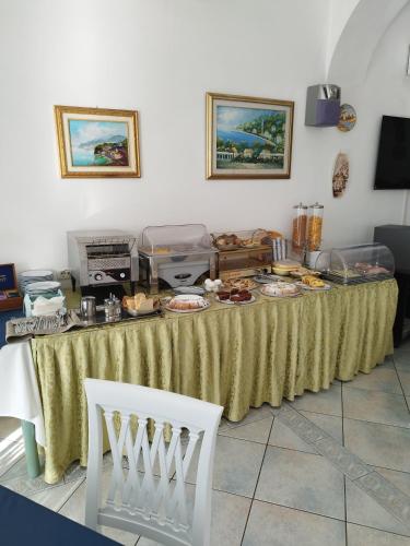 Una mesa con platos de comida encima. en Hotel La Perla, en Praiano