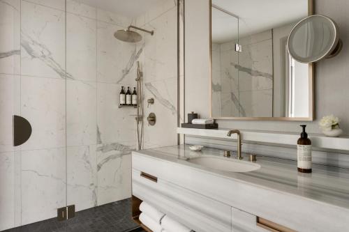 a bathroom with a sink and a shower with a mirror at Fairmont Château Lake Louise in Lake Louise