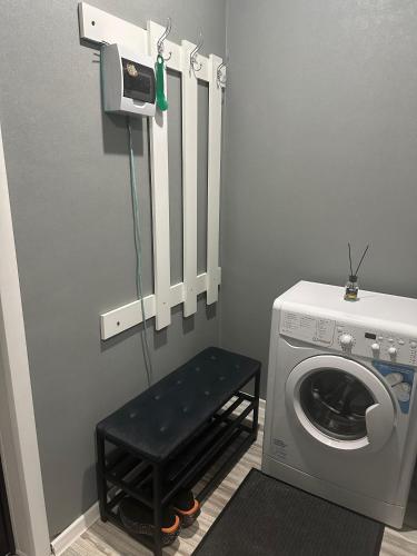 a laundry room with a washing machine and a stool at 1-комнатная квартира студия in Ekibastuz