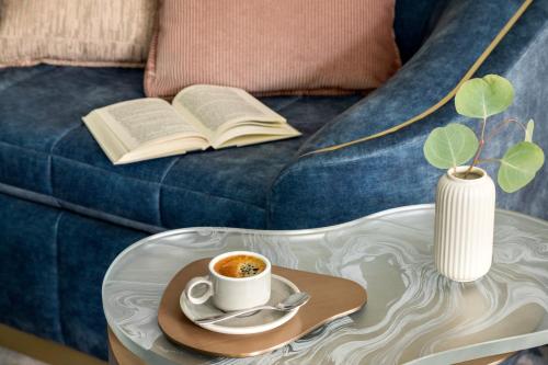 a coffee table with a cup of coffee and a book at Fairmont Château Lake Louise in Lake Louise