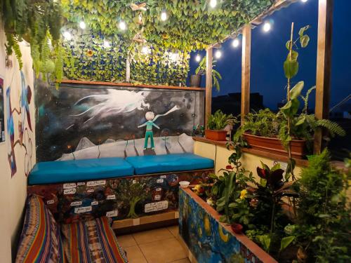 a room with a bed with plants and a painting at Passion Hostel - Barranco in Lima