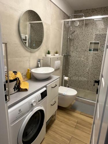 a bathroom with a washing machine and a sink at Alany Apartment Zagreb in Zagreb