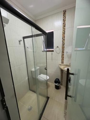 a bathroom with a glass shower with a toilet at Pousada Recanto da Cascata in Águas de Lindóia