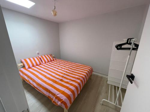 a bedroom with an orange and white striped bed at Fogar en Soutelo in Forcarei