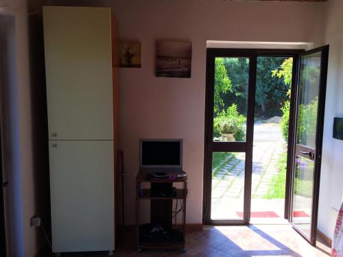 a room with a refrigerator and a television and a door at Goddess Yard in Tropea