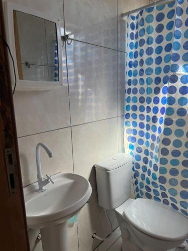 a bathroom with a toilet and a sink and a shower at Kitinet completa com varanda Praia de Caiobá in Matinhos