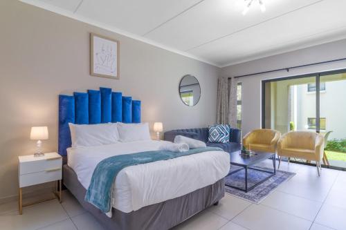 Un dormitorio con una cama grande con cabecero azul. en AlimamaSpaces - Rodney's Studio, en Fourways