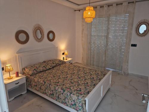a bedroom with a bed and two mirrors on the wall at Staycation Yakout in Mansouria