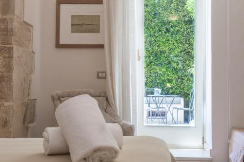 a bedroom with a bed and a window with a view at Hotel Novecento in Scicli