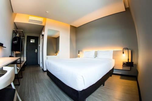 a large white bed in a hotel room at Naalt Hotel Joinville in Joinville