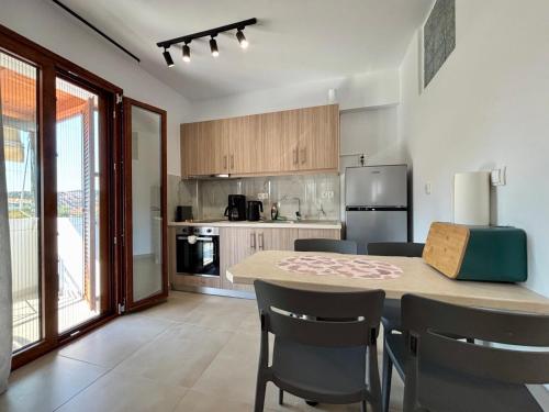 a kitchen with a table and chairs in a room at SummerLoft3 in Sivota