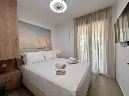 a bedroom with a white bed with towels on it at SummerLoft3 in Sivota