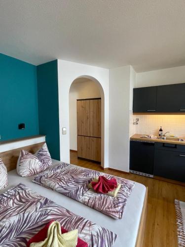 a room with two beds in a room with a kitchen at Haus Sylta in Fischen