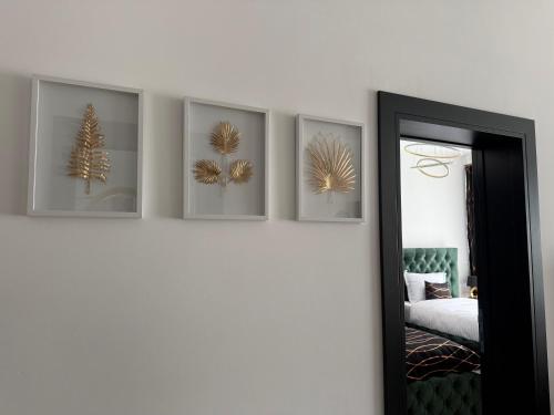 a room with four pictures on the wall and a mirror at Golden Hill Palace in Novi Pazar
