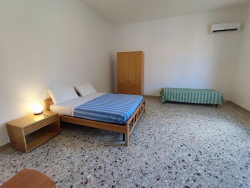 a small bedroom with a bed and a nightstand and a bed sidx sidx sidx at l'Araucaria casa vacanze in Marsala