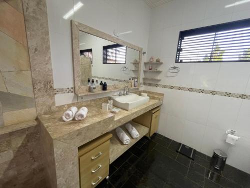 un bagno con lavandino e specchio di Belíssimo Apartamento Stella Maris -Casa de Carrara3 ad Andradina