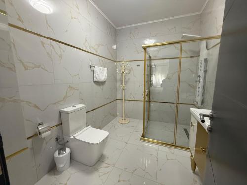 a bathroom with a toilet and a glass shower at Golden Hill Palace in Novi Pazar