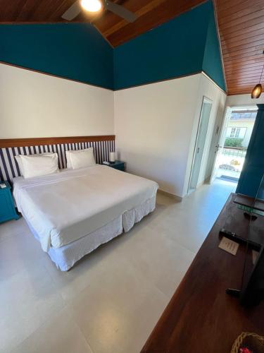 a bedroom with a large bed and a blue wall at Pousada Corsario Buzios in Búzios