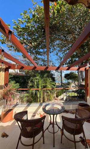 a patio with a table and chairs and trees at Pousada Corsario Buzios in Búzios
