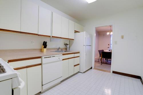 an empty kitchen with white cabinets and a table at Elegant Apartment w Views at Crystal City in Arlington