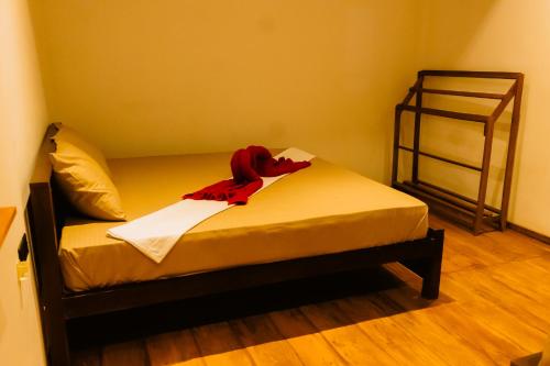 a bedroom with a bed with a red robe on it at Captains Cabins Arugambay in Arugam Bay